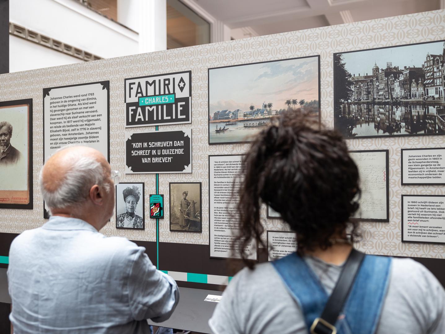 Visitors looking at excerpts from the Famiri/Family exhibition. 