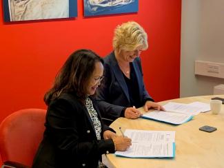 Ms Rita Tjien Fooh, director of the National Archives of Suriname, and Ms Afelonne Doek, director of the National Archives of the Netherlands, sign the renewed cooperation.