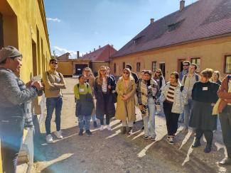 Group of young people standing in a street and listening to someone on the left