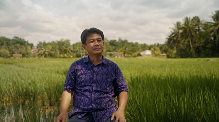 An Indonesian man sitting in a rice field in Indonesia